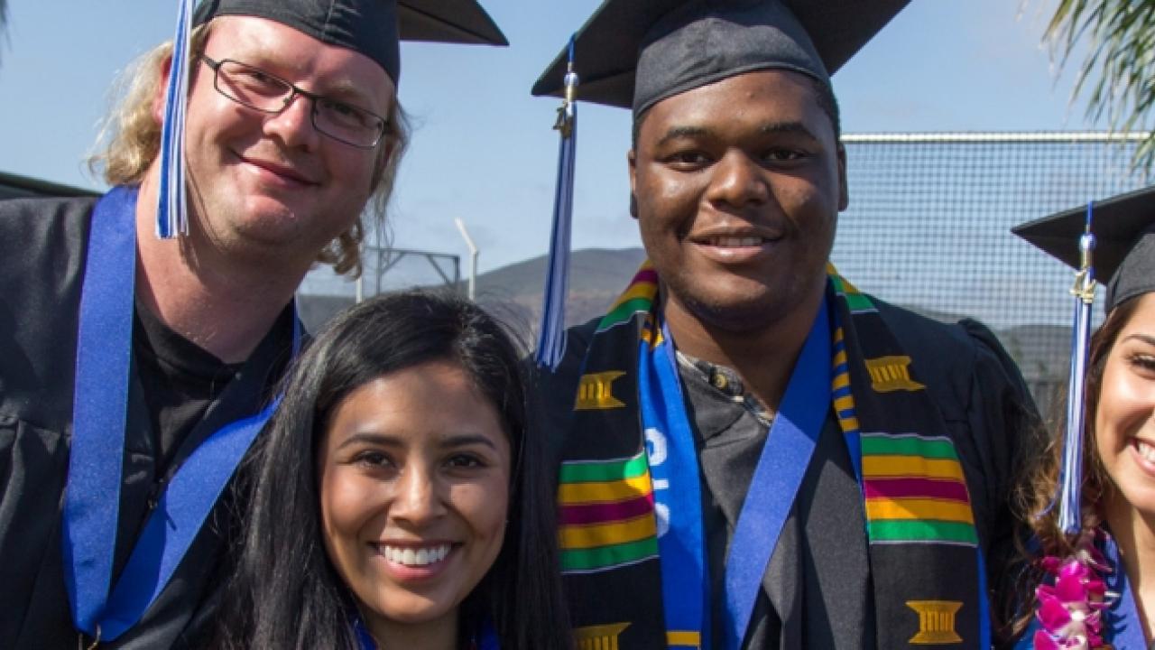 4 students in graduation caps and gowns