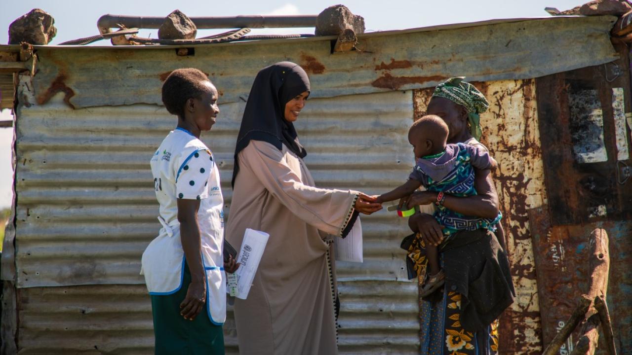 Action Against Hunger health workers greet a grandmother and her grandchild in Kenya. // Photo by Abel Gichuru