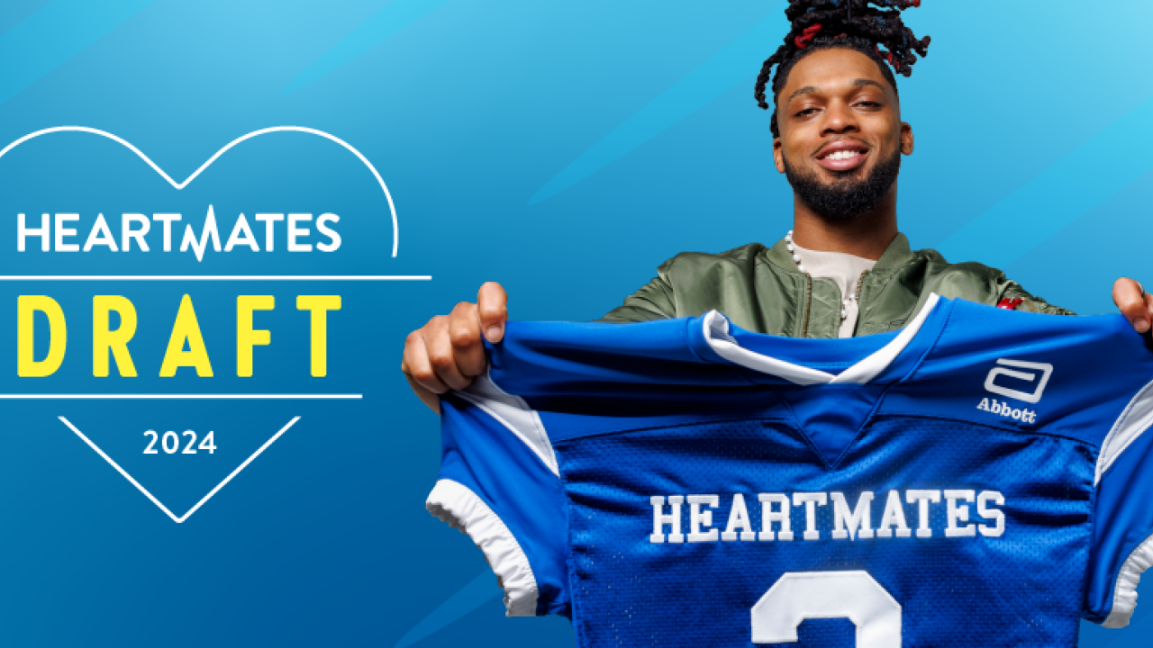 Damar Hamlin holding a blue "Heartmates" football jersey.