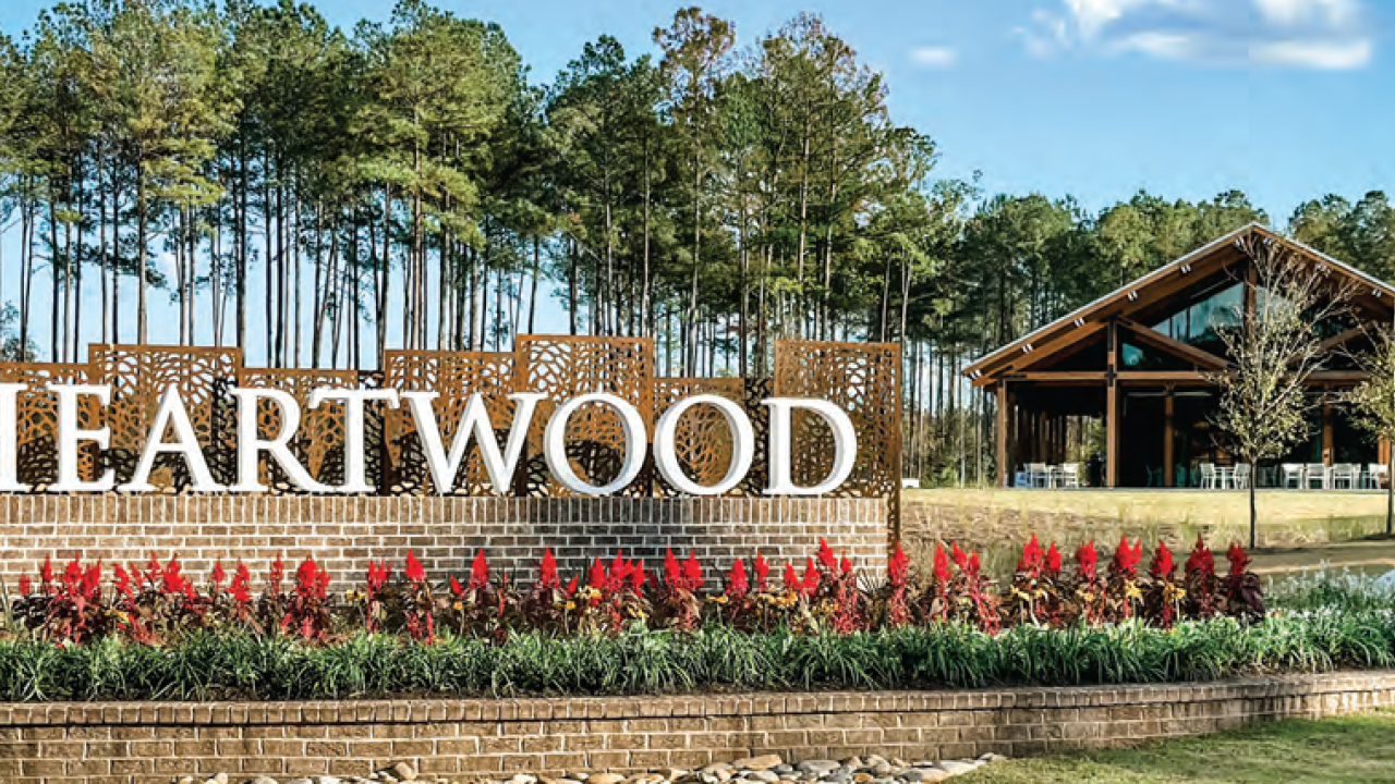 An outdoor sign "Heartwood" and a home in the distance.