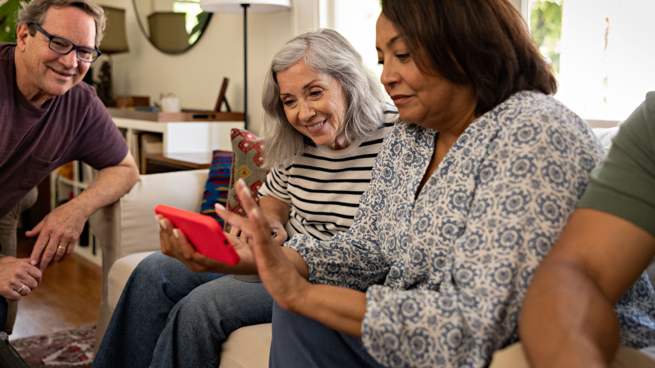 People smiling and using a cell phone