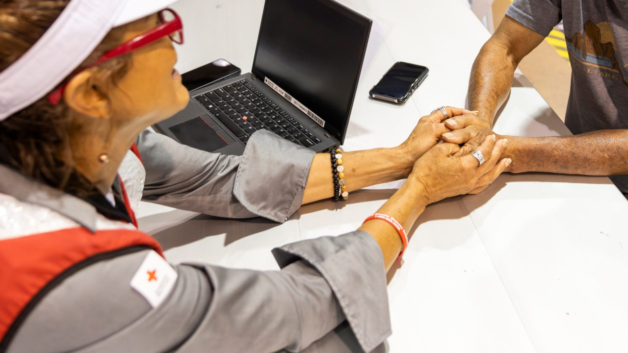 Red Cross volunteer holding someone's hands