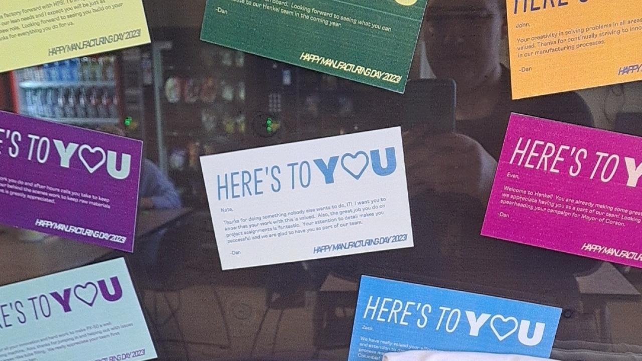 Colorful "Here's to you" signs on a window.
