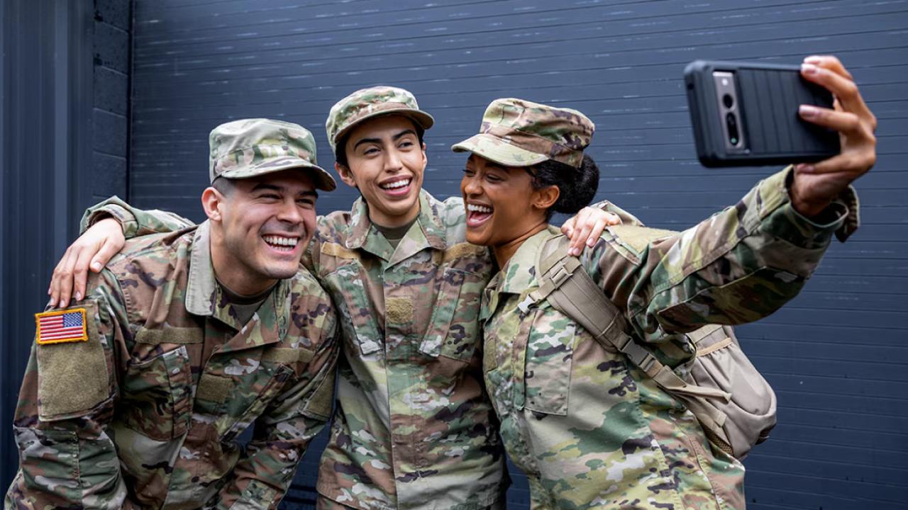 Three veterans with their arms around each other taking a photo