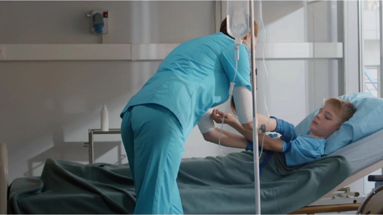 Child getting an IV in a hospital bed