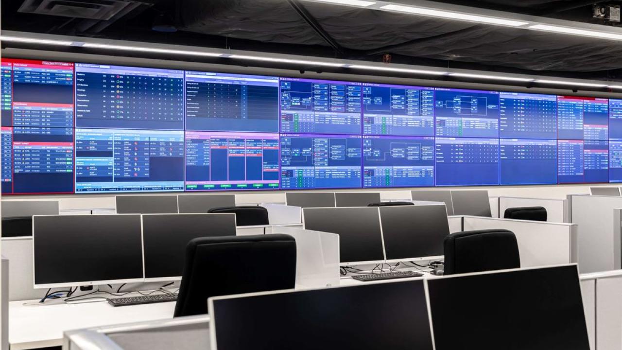 A call center with multiple digital screens at the front.