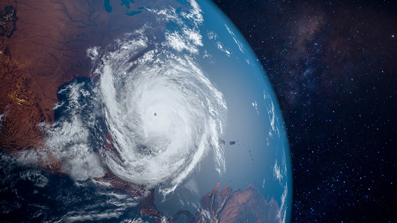 View from outer space towards the Earth. A large hurricane is central.