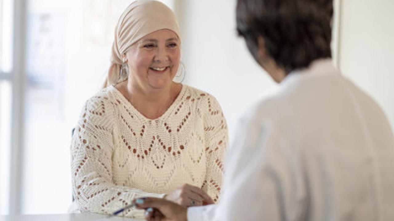 Female cancer patient consulting with a doctor. Patient is wearing a headscarf.
