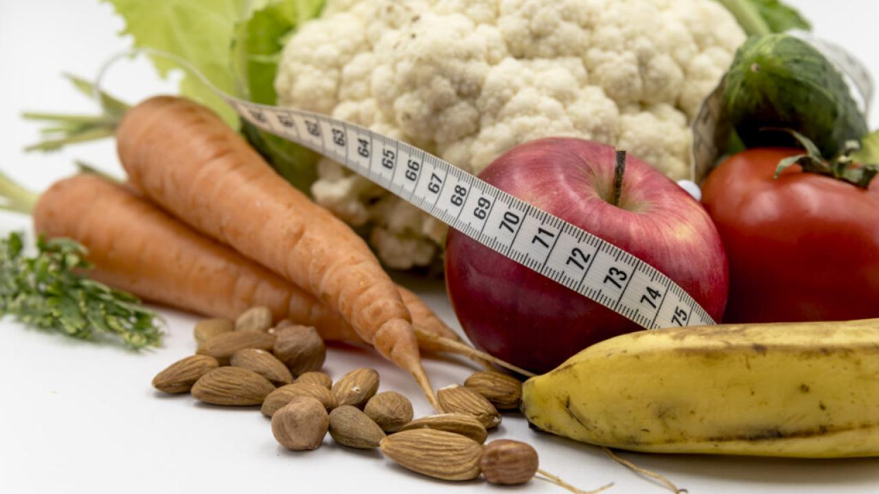 fresh vegetables, nuts, and a measuring tape