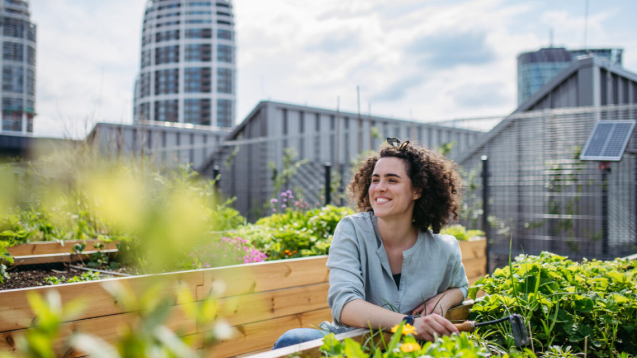 Woman smiling next to a garden bed