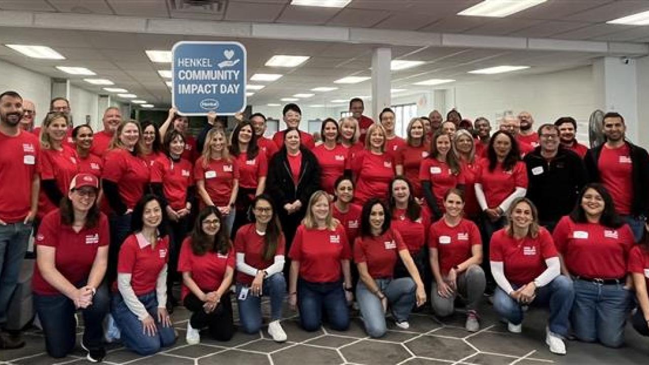 A large group of volunteers posed in an office setting.