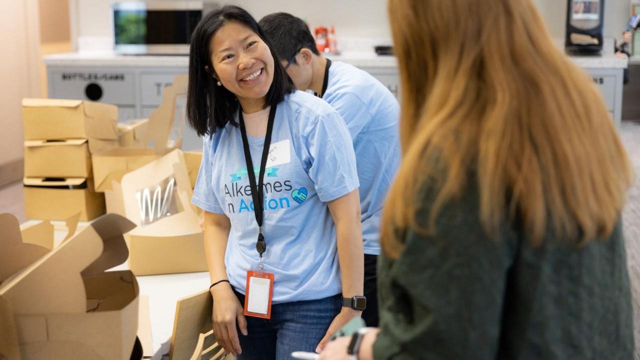 Volunteers smiling by open boxes.