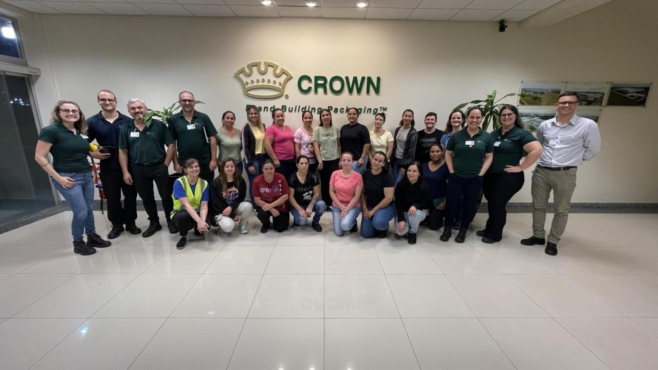 A group posed in an entryway. "Crown" sign on the wall behind them.