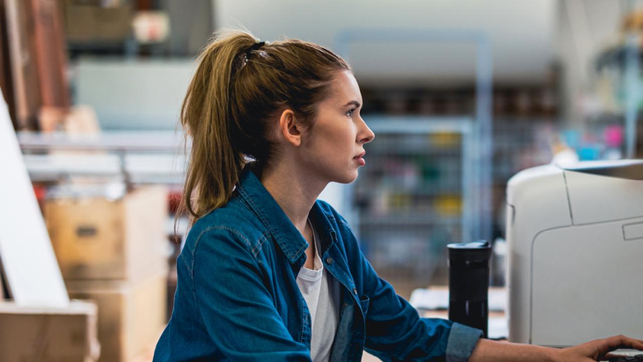 A person working on a desktop computer in an office setting.