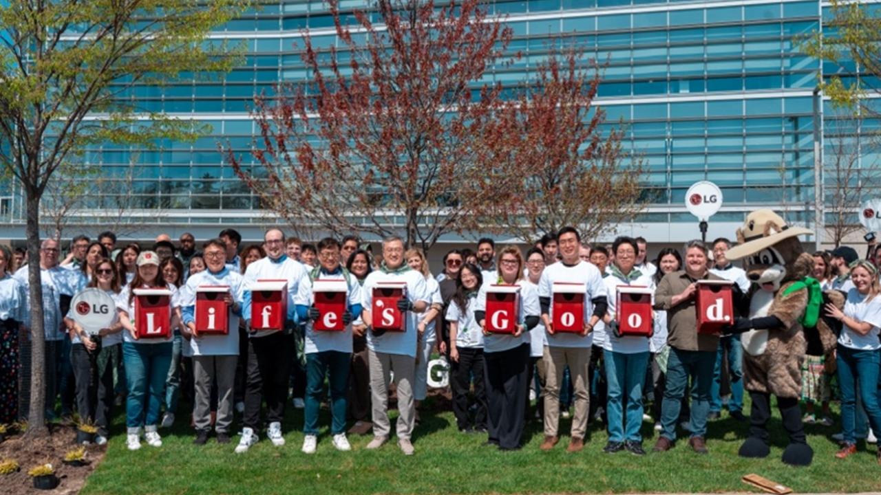 A group of people outside of a building, holding letters that spell "life's good."