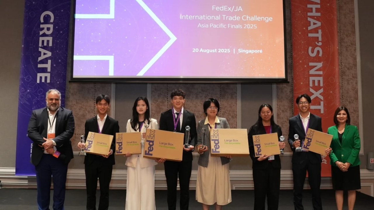 Students smiling and holding FedEx boxes