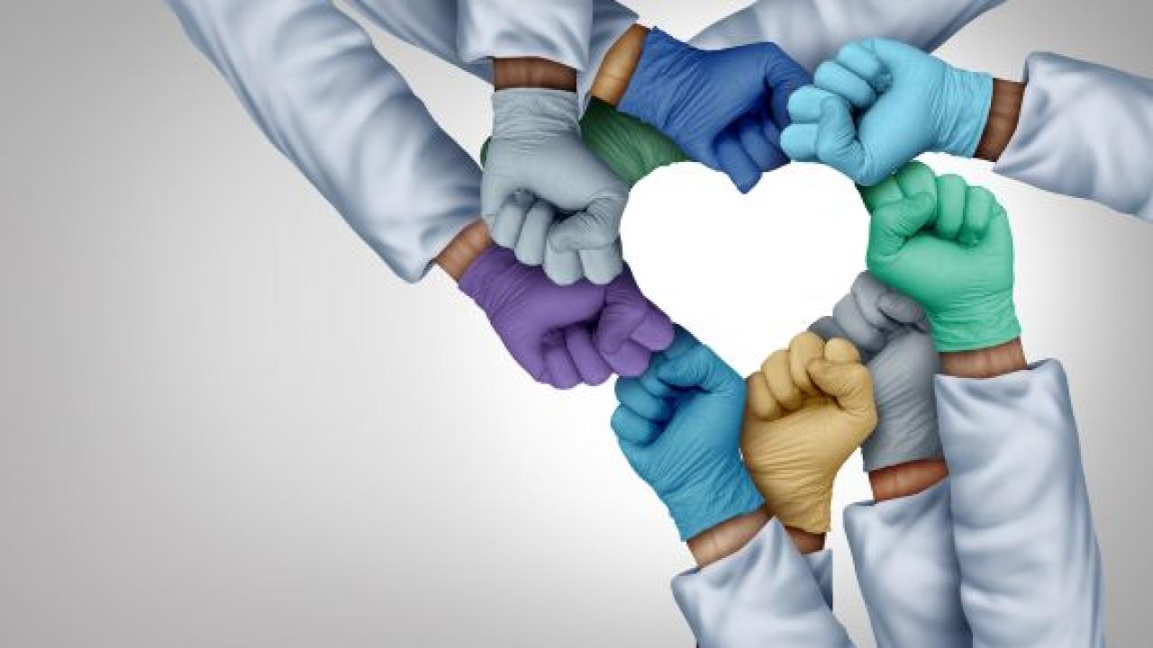group of gloved hands together forming a heart