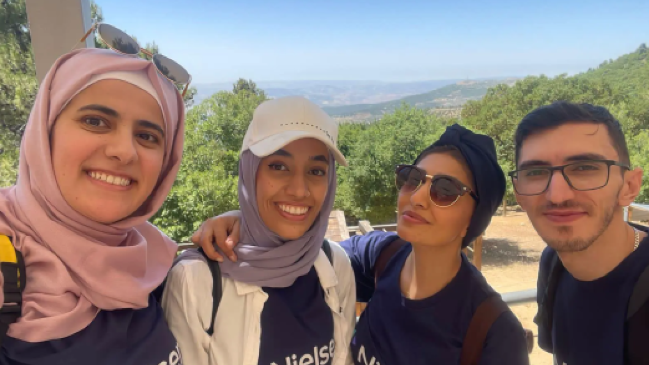Four people take group selfie 