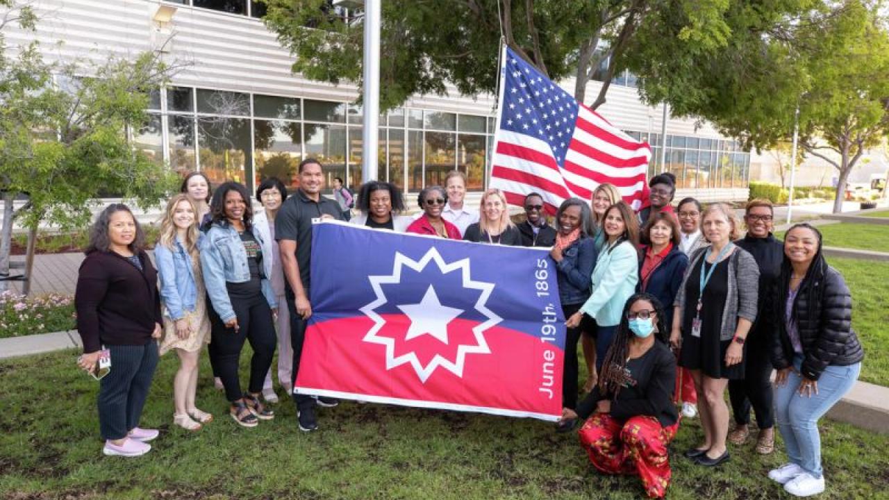 Employees posing with Juneteenth flag