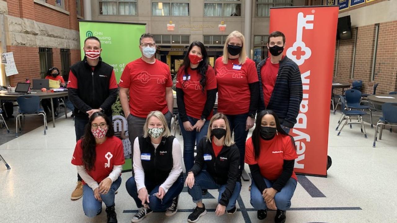 Nine KeyBank volunteers pose for a group photo. All are wearing red KeyBank t-shirts and masks.