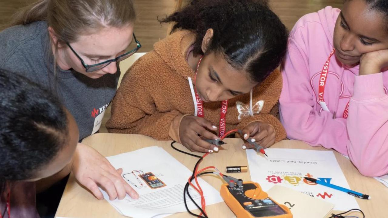 Kids working together with written instructions and electronics, wires and batteries.