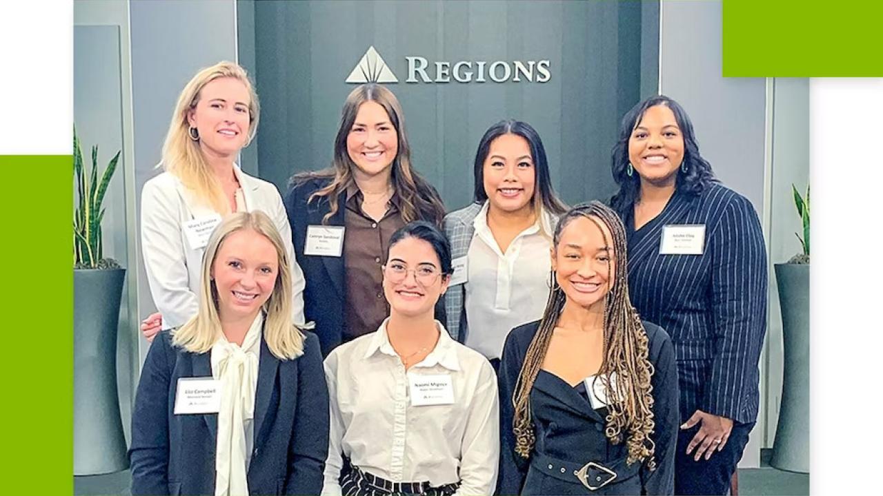 Six people posed, a Regions sign behind them.