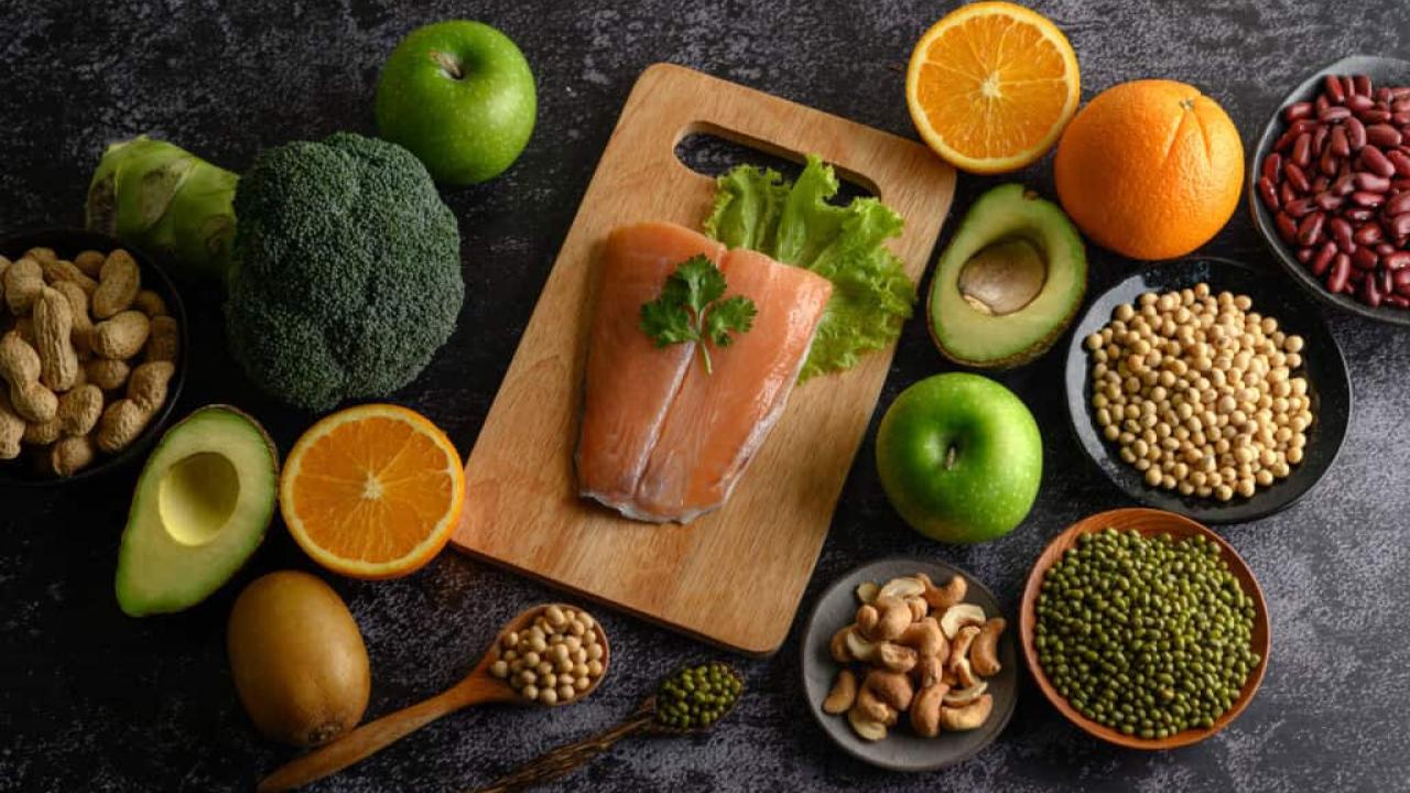 Legumes, vegetables and fruits shown on a cutting board.