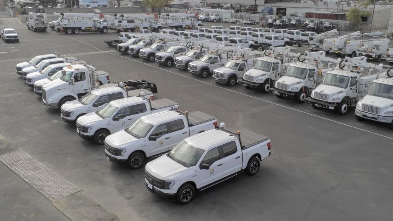 Aerial view of a parking lot full of identical trucks and service vehicles.