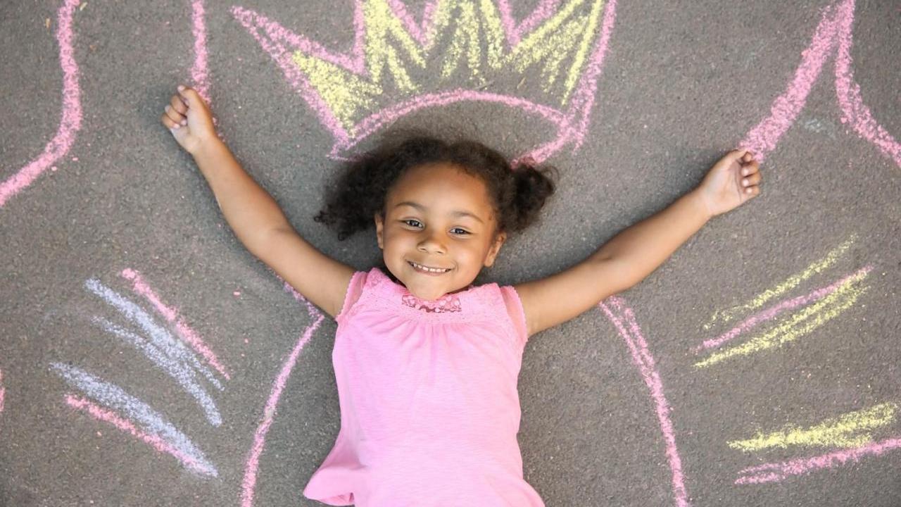 A little girl laying on a chalk outline
