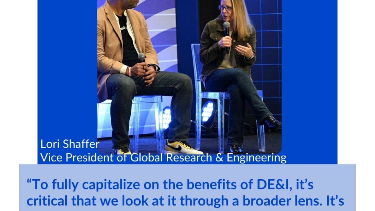 Two people talking and sitting on a stage with microphones