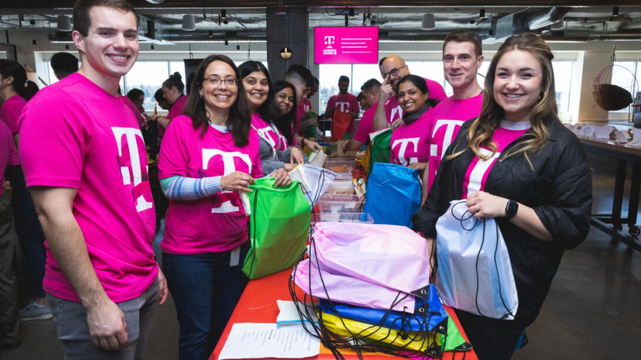 Volunteers packing colorful bags in two lines.