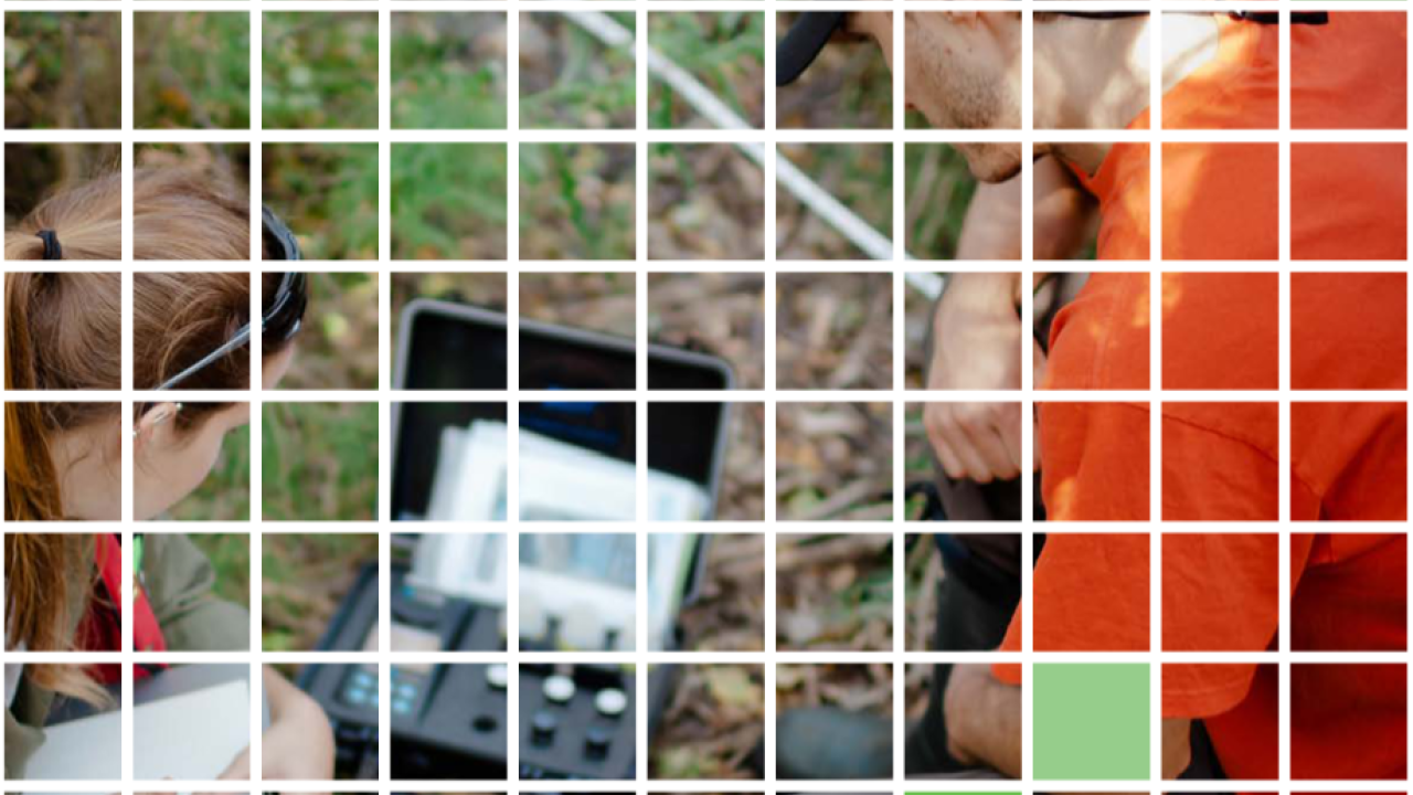 square grid over a picture of two people looking at a small device sitting on the ground. One takes notes on a pad of paper.