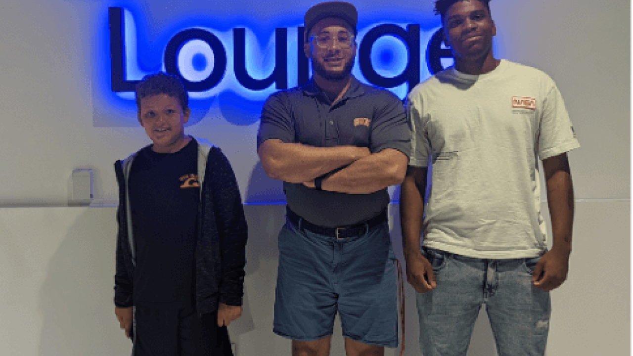 3 people standing in front of a "lounge" sign