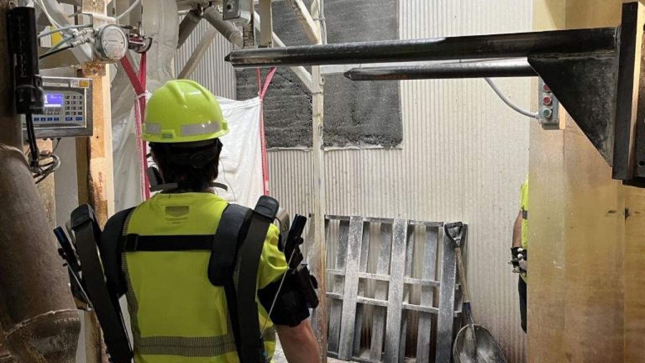 A person in protective gear in a manufacturing area.