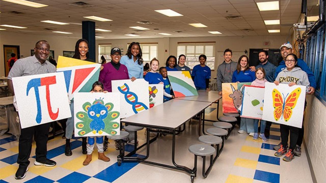 group showing off their paintings 