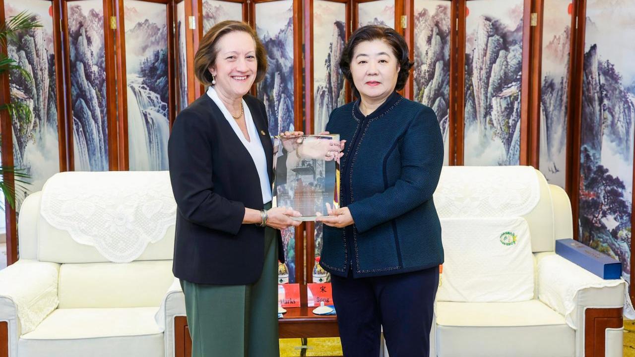 two women holding plaque 