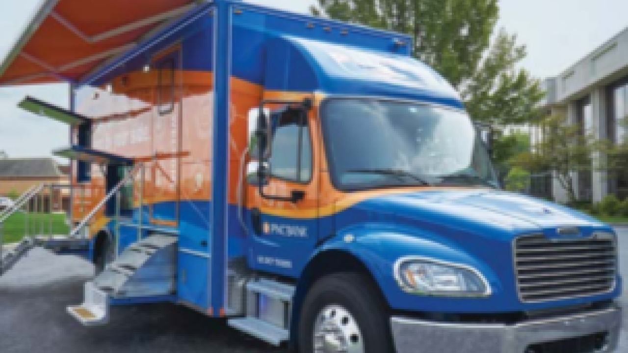 A 'mobile branch' PNC truck parked with steps and awning extended.