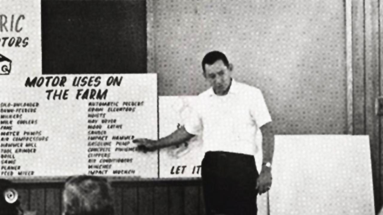 An old photo, a representative from Duke Power giving a presentation to a group of children about motor uses on the farm