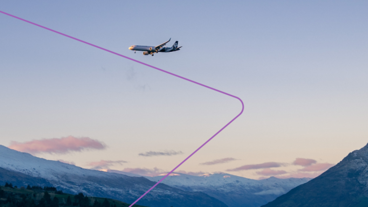 A plane in flight over mountain terrain.