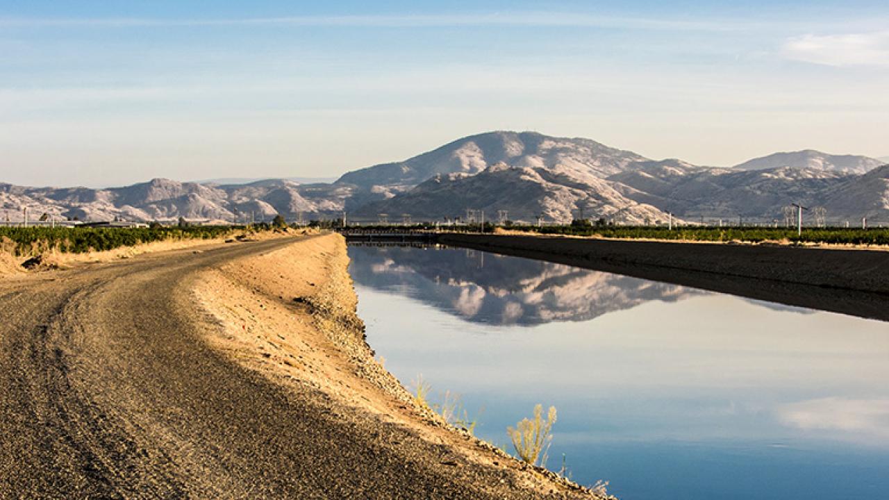 A dirt road with mountains in the background