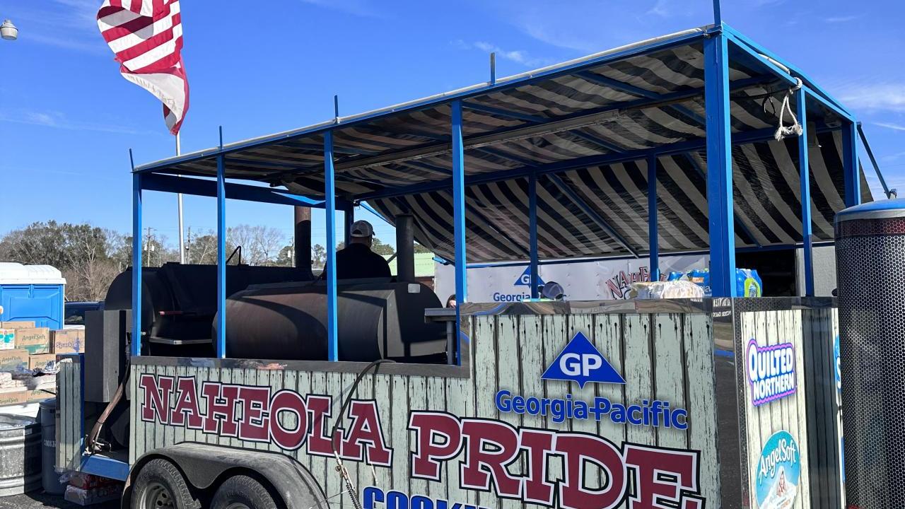 Cooking trailer with open sides and "Naheola Pride cooking team" on the side with Georgia-Pacific logo