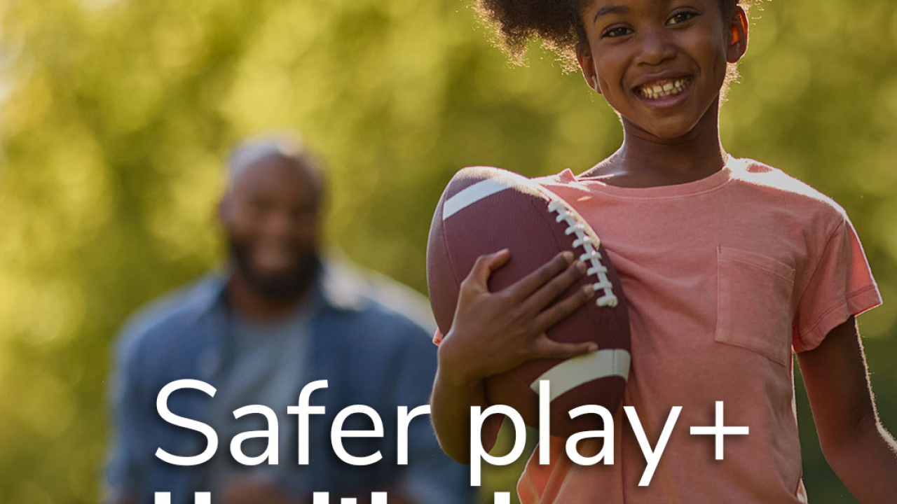 A child holding a football, with words "Safer play + Healthy lawns:"