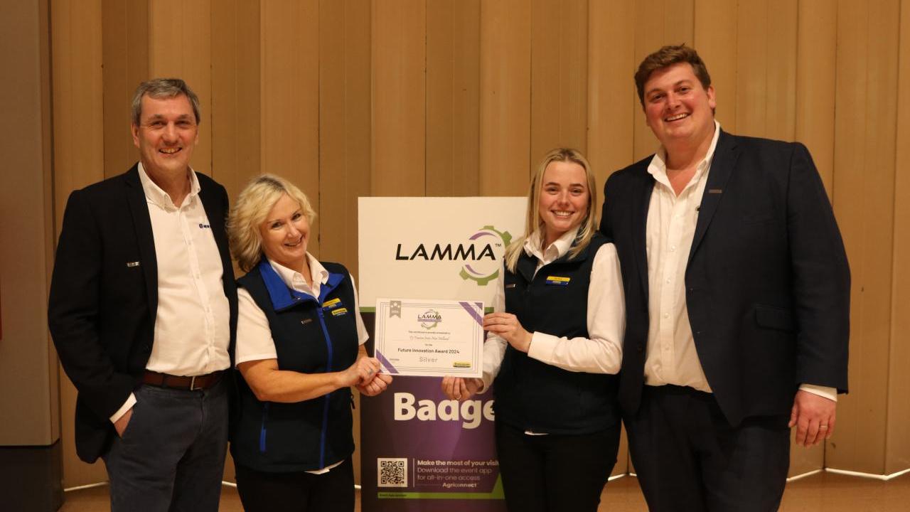 Four people standing together holding an award