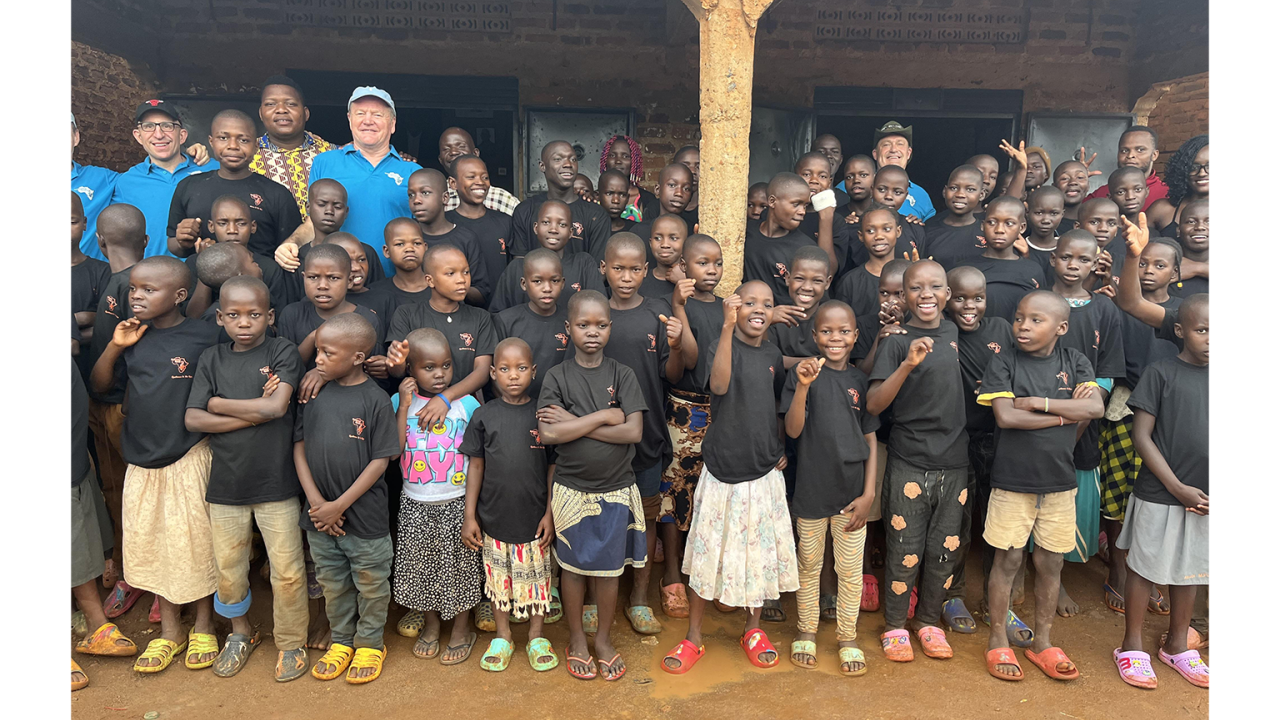 A large group of children standing together with a few adults