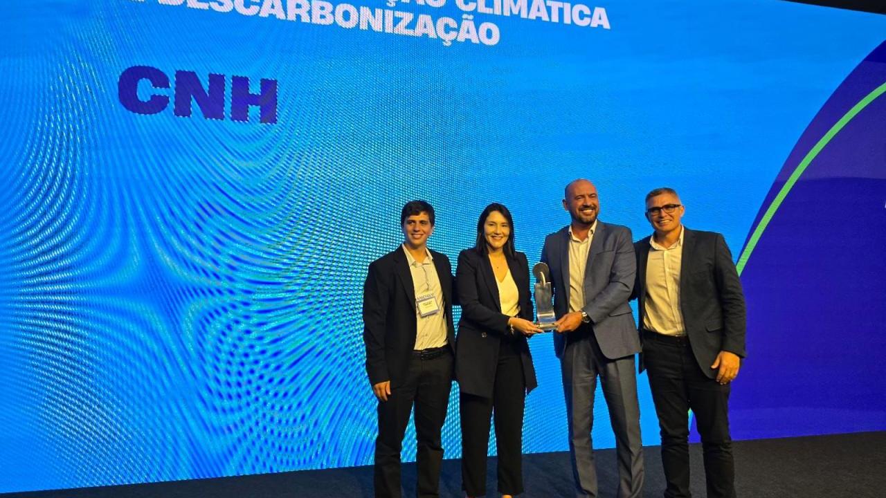 four people holding an award on a stage