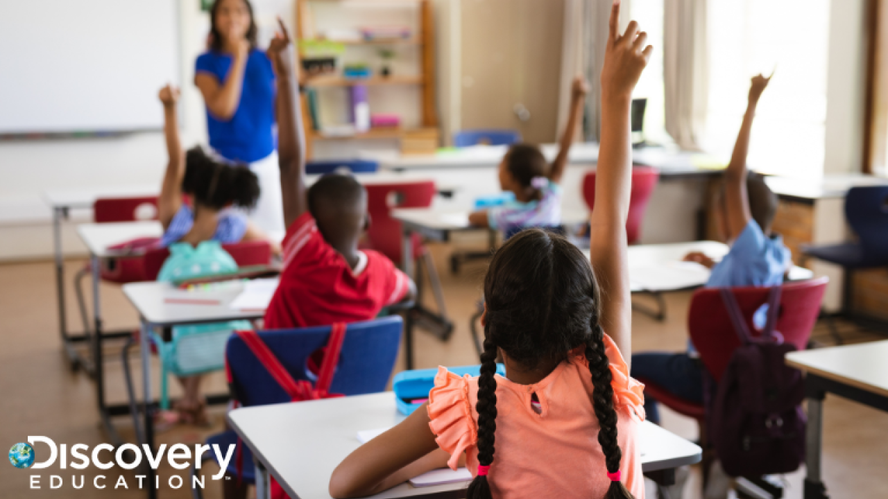 Children raising their hands in a classroom