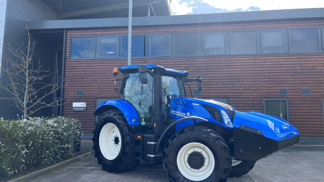 A blue New Holland tractor in a parking lot.