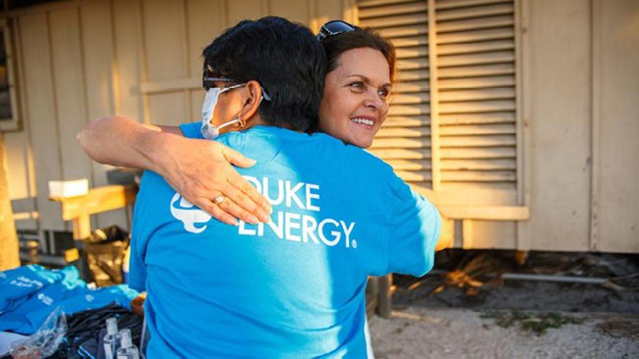 two people in duke energy t-shirts hugging