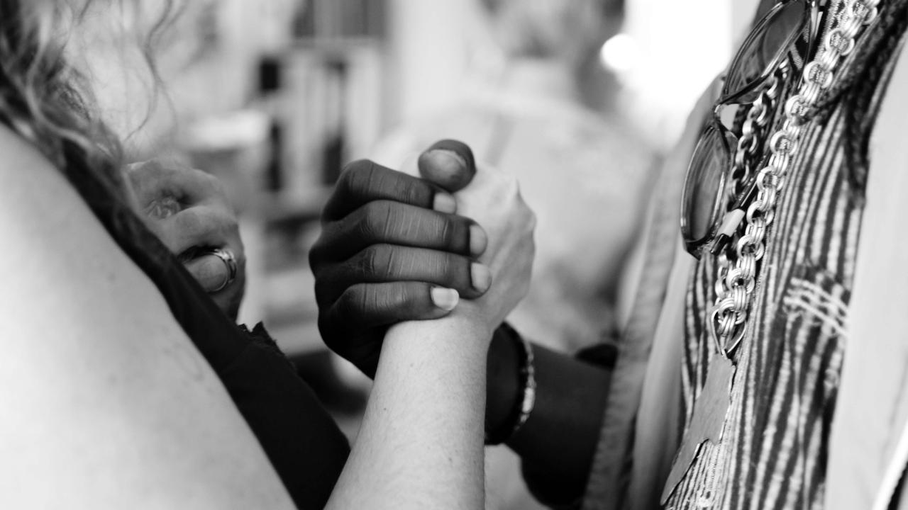 Two people clasping hands between them