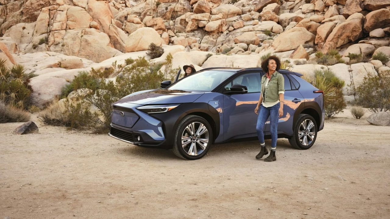 Person standing next to a Subaru vehicle